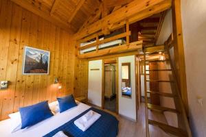 Chalet Haut Fort Ski Injacuzzi في مورزين: غرفة نوم مع سرير بطابقين وسلم