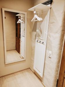 a bathroom with a large mirror and hangers at Vintage-Design Ferienwohnung Florentine in Bad Klosterlausnitz