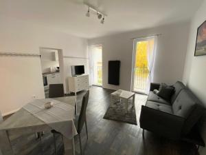 - un salon avec un canapé et une table dans l'établissement Cozy Apartments in Zwickau, à Zwickau