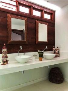 a bathroom with two sinks and two mirrors at Villa Patara in Marechal Deodoro