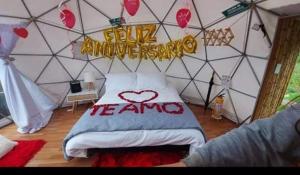 Domo -glamping luna في راكيرا: غرفة بسرير مع لافتة تقول مرحباً أمازون