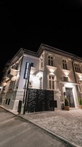 a white building with a sign on the side of it at George&Dragon Rooms in Bucharest
