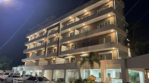 a large building with cars parked in front of it at All Seasons Hotel in Bayahibe