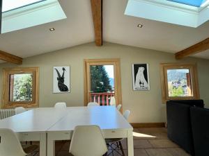 uma sala de jantar com uma mesa branca e janelas em The Castle, 10 Bedroom Chalet, Chamonix Centre em Chamonix-Mont-Blanc