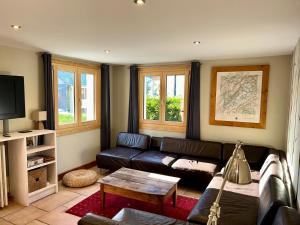 - un salon avec un canapé en cuir et une table dans l'établissement The Castle, 10 Bedroom Chalet, Chamonix Centre, à Chamonix-Mont-Blanc