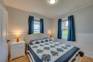 1 dormitorio con 1 cama y 2 ventanas con cortinas azules en Inviting and Spacious Vacation Rental in Pittsburg!, en Pittsburg