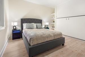 a bedroom with a bed and two lamps on a wooden floor at Brand New Stylish Home for Your Family in Tallahassee
