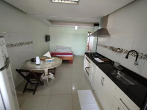 una pequeña cocina con mesa y fregadero en VENTO E SAL - Apartamento MAR, en Ilhéus