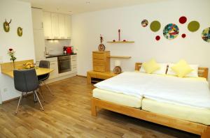 a bedroom with a bed and a table and a kitchen at Appartement Schwarzwaldstüble in Oberharmersbach