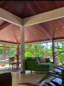 a living room with a green couch and a wooden ceiling at Villa Patara in Marechal Deodoro