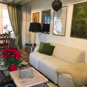 ein Wohnzimmer mit einer weißen Couch und einem Tisch in der Unterkunft Maison spacieuse près de Vienne-en-Arthies avec jardin in Vienne-en-Arthies