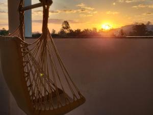 a hammock with the sunset in the background at PousaDinháChica Hospedagem perto de Tiradentes Minas in São João del Rei