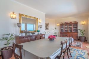 een grote eetkamer met een tafel en stoelen bij Villa Amelia in Falésia by the Sea in Caniço