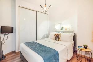 a bedroom with a large white bed and a tv at Santa Triada in Heraklio