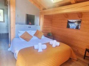 a bedroom with a bed with two white candles on it at Les Drus - Luxury Chalet for 8 in Chamonix-Mont-Blanc