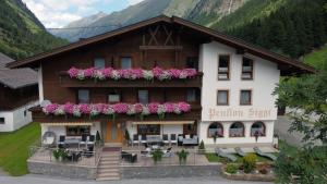 a building with flowers on the front of it at Hotel Pension Siggi in Sankt Leonhard im Pitztal