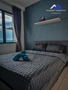 a blue stuffed animal laying on top of a bed at 1 Tebrau By Elegant Johor Bahru in Johor Bahru