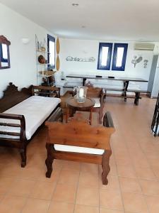 a room with two beds and a table and chairs at HONES - RELAX HOUSE in Perissa