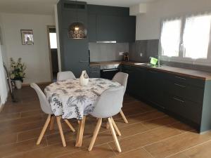 uma cozinha com uma mesa e cadeiras numa cozinha em Coup d'œil em Bullet