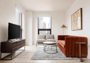 uma sala de estar com um sofá e uma televisão em Amazing 4 Bedroom Apartment In Chambers Street em Nova York