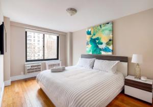 a bedroom with a bed and a painting on the wall at Amazing 4 Bedroom Apartment In Chambers Street in New York