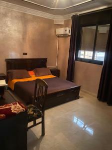 - une chambre avec un lit, une chaise et une fenêtre dans l'établissement riad oujda, à Oujda