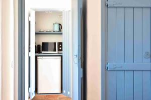 uma porta que dá acesso a uma cozinha com um micro-ondas em Herdade Do Touril na Zambujeira do Mar