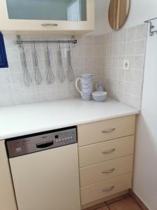 a kitchen with a white counter top with a dishwasher at HONES - RELAX HOUSE in Perissa