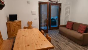 a living room with a wooden table and a couch at APPARTAMENTO BELLAVISTA in Caspoggio