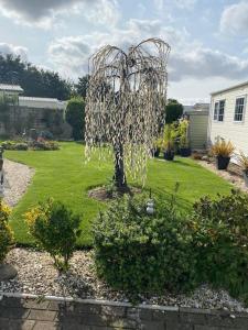 a garden with a metal sculpture in a yard at 2 Bed, 2 Bath Lodge Style Caravan with Hot Tub & Private Garden in Patrington