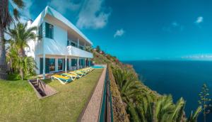 een huis op een heuvel naast de oceaan bij Villa Amelia in Falésia by the Sea in Caniço