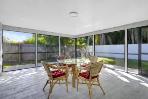 a patio with a table and chairs on a balcony at Bungalow Close to Naples Beaches in Naples