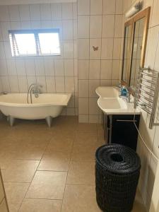 a bathroom with a tub and a sink and a tub at Langstrand Self Catering Villa - Sunset & Sunrise Rooftop including BBQ & Fireplace in Langstrand