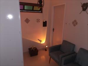 uma sala de estar com uma cadeira e um candeeiro em SUITES VISTA MAR AZUL em Saquarema