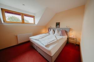 Schlafzimmer mit einem großen weißen Bett und einem Fenster in der Unterkunft Ferienhäuser Inge und Seeblick in Oberaichwald
