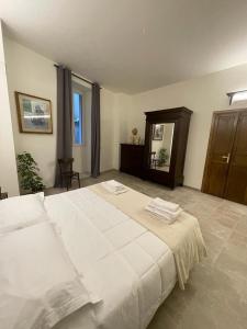 1 dormitorio grande con 1 cama grande con sábanas blancas en Baroon Bistrot & Rooms, en Polizzi Generosa