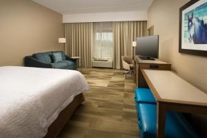 a hotel room with a bed and a desk with a television at Hampton Inn & Suites Baltimore North/Timonium, MD in Timonium