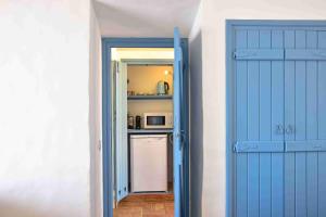 eine blaue Tür, die zu einer Küche mit einem Kühlschrank führt in der Unterkunft Herdade Do Touril in Zambujeira do Mar