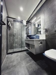 a bathroom with a sink and a glass shower at Kadıköy Duck hotel in Istanbul