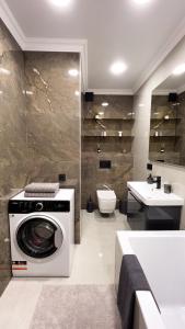 a bathroom with a washing machine and a sink at Brand New and Fully Furnished Apt in Buiucani in Chişinău