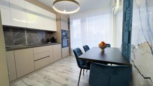 a kitchen with a table and chairs in a room at Brand New and Fully Furnished Apt in Buiucani in Chişinău