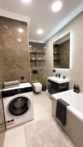 a bathroom with a washing machine and a bath tub at Brand New and Fully Furnished Apt in Buiucani in Chişinău