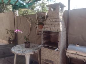 an outdoor pizza oven with a table and a table sidx sidx sidx at Casa 04 do Condomínio Privê Portal das Flores in Gravatá