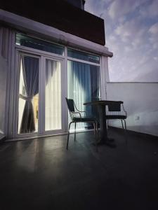 a table and two chairs on a balcony with a window at Kadıköy Duck hotel in Istanbul