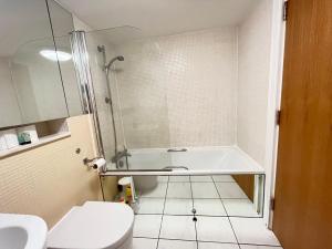 a bathroom with a tub and a toilet and a sink at Serviced apartment in Kensington London Victoria in London