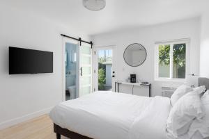a white bedroom with a bed and a tv at Sunny Studio near Culver City in Los Angeles
