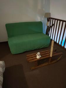 uma sala de estar com um sofá verde e uma mesa em Le Seignus: superbe studio avec vue sur les pistes em Allos