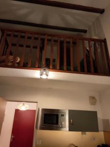 uma cozinha com um micro-ondas e uma escada em Le Seignus: superbe studio avec vue sur les pistes em Allos