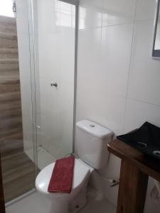 een badkamer met een toilet en een glazen douche bij Pousada Ilha das Peças LG in Fortaleza