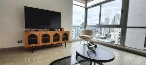 a living room with a flat screen tv and a chair at Fascinating Apartment City Center - PH Quartier Atlapa in Panama City
